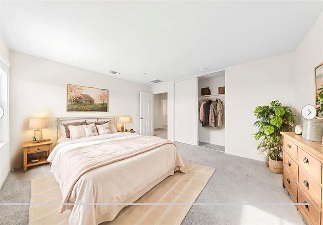 a bedroom with a bed and a potted plant
