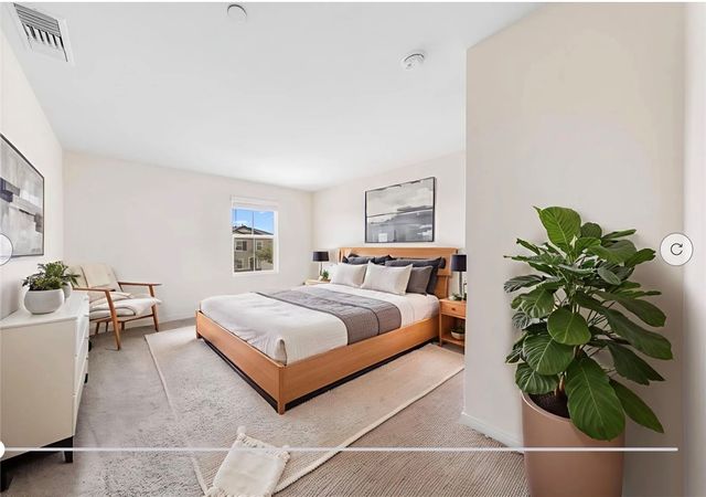 a bedroom with a bed and a potted plant