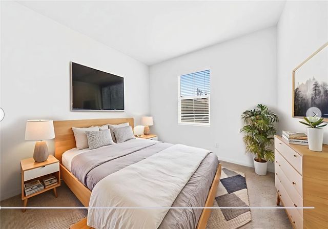 a bedroom with a bed potted plant with the window