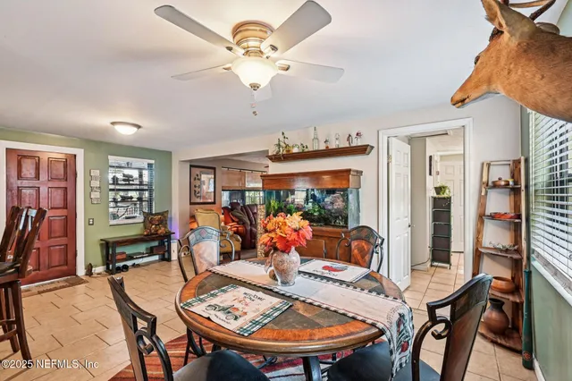 a living room with furniture a flat screen tv and floor to ceiling window