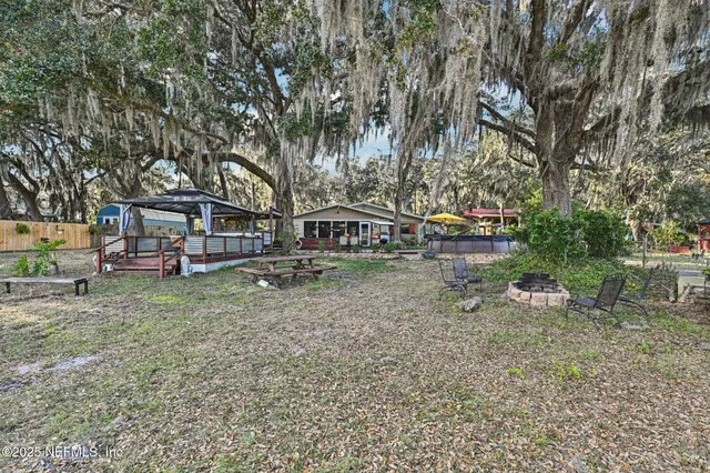 an aerial view of ocean and residential houses with outdoor space