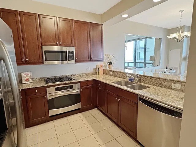 a kitchen with stainless steel appliances granite countertop wooden cabinets a sink and a stove