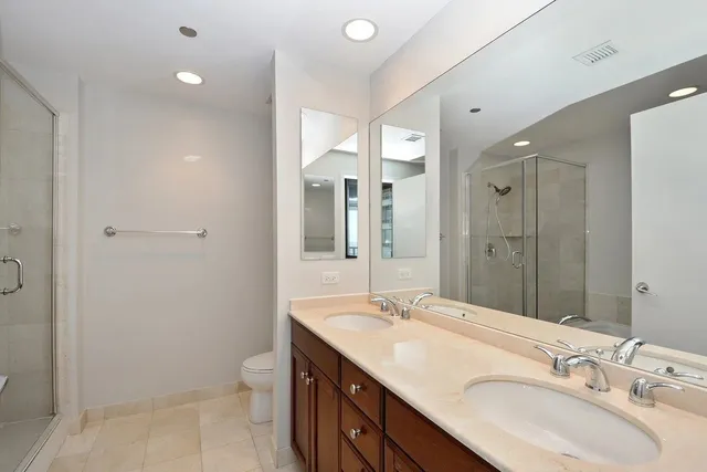 a bathroom with a double vanity sink toilet and shower