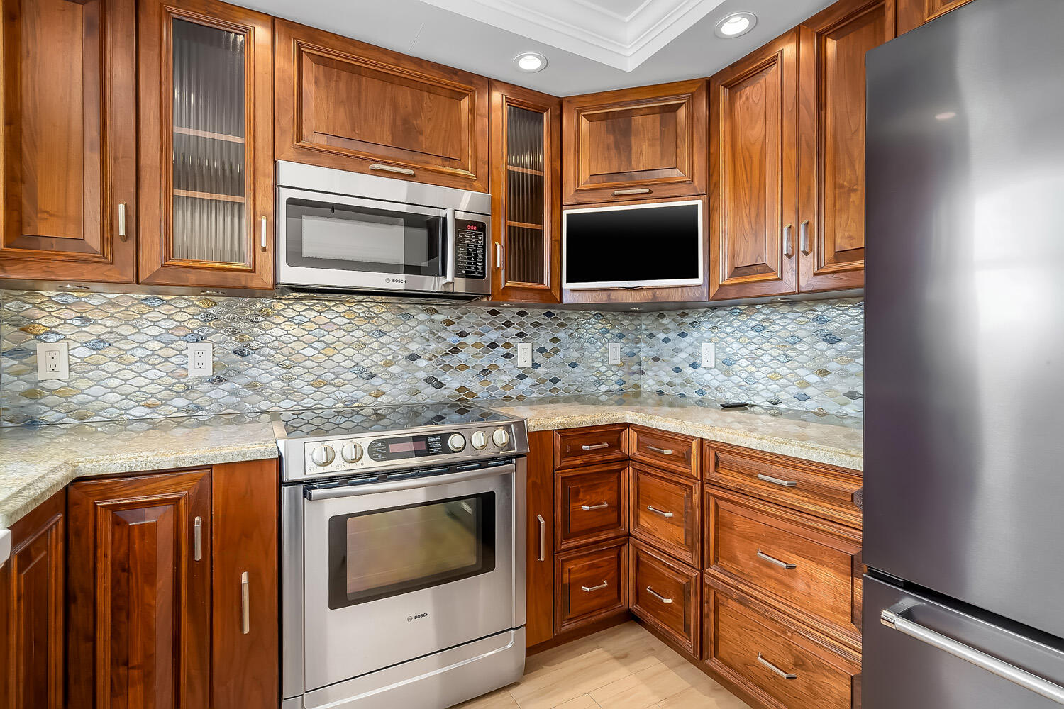 215 North Birch Road, Unit 5B Fort Lauderdale, FL 33304 - Photo 34 of 73 a kitchen with stainless steel appliances granite countertop wooden cabinets and a stove top oven