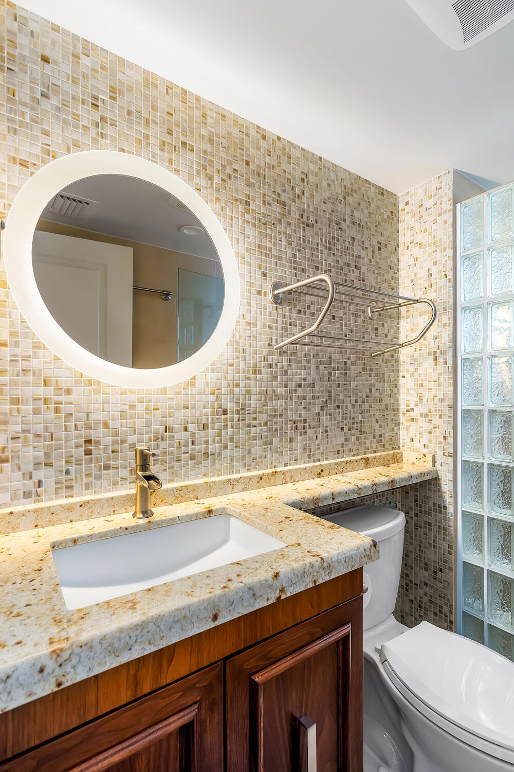215 North Birch Road, Unit 5B Fort Lauderdale, FL 33304 - Photo 45 of 73 a bathroom with a granite countertop toilet sink and mirror