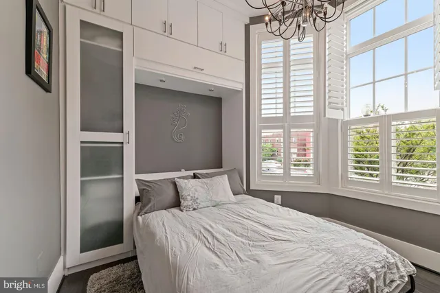 a bedroom with a bed dresser and a window