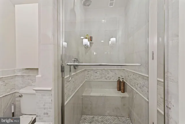 a bathroom with a granite countertop sink a toilet and mirror