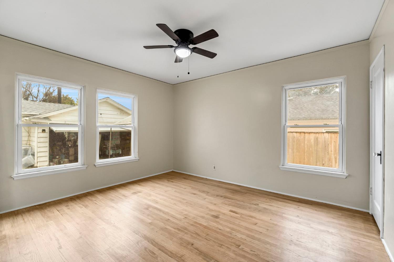 215 East Clinton Avenue Fresno, CA 93704 - Photo 18 of 29 a view of an empty room with a window and wooden floor