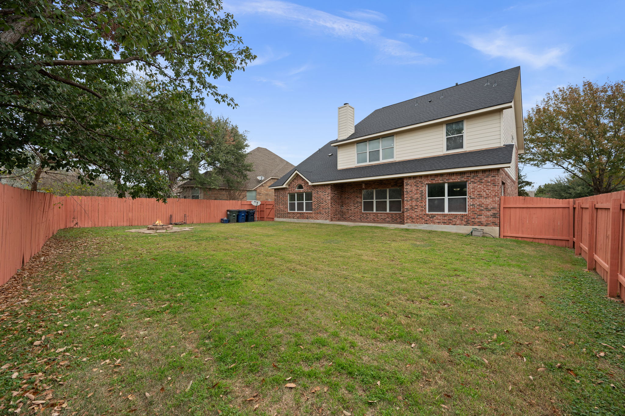 2415 Elkhorn Ranch Road Leander, TX 78641 - Photo 25 of 38 Back of property featuring a fenced backyard, a chimney, brick siding, and roof with shingles