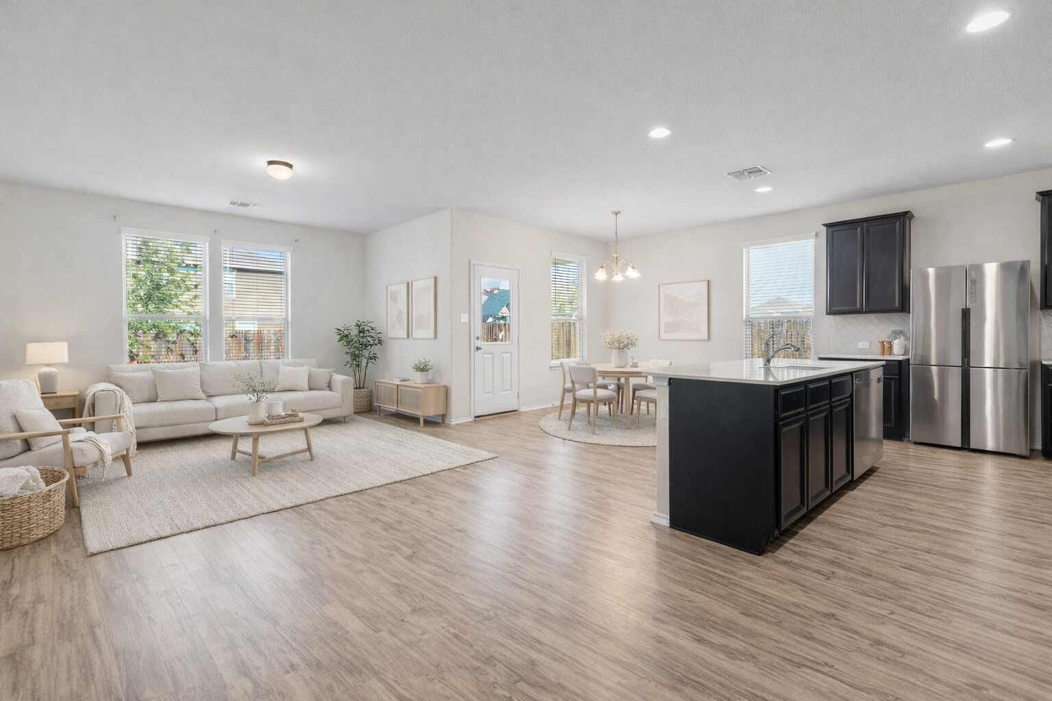332 Spotted Rail Ridge Leander, TX 78641 - Photo 36 of 38 Virtually staged. Kitchen with open floor plan, an island with sink, appliances with stainless steel finishes, hanging light fixtures, and light wood finished floors