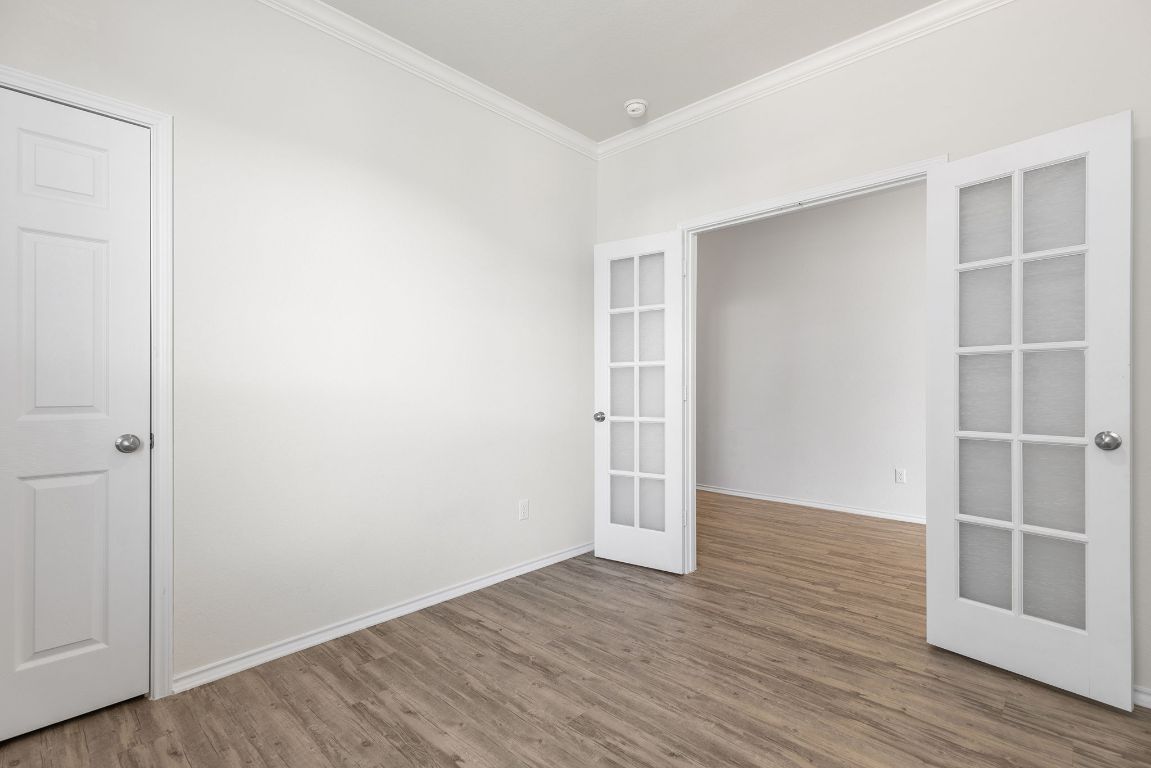 332 Spotted Rail Ridge Leander, TX 78641 - Photo 10 of 35 Main floor office or bedroom #2 featuring crown molding, wood finished floors, and french doors