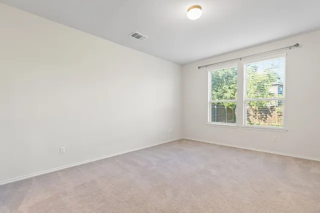 a view of an empty room with wooden floor and closet