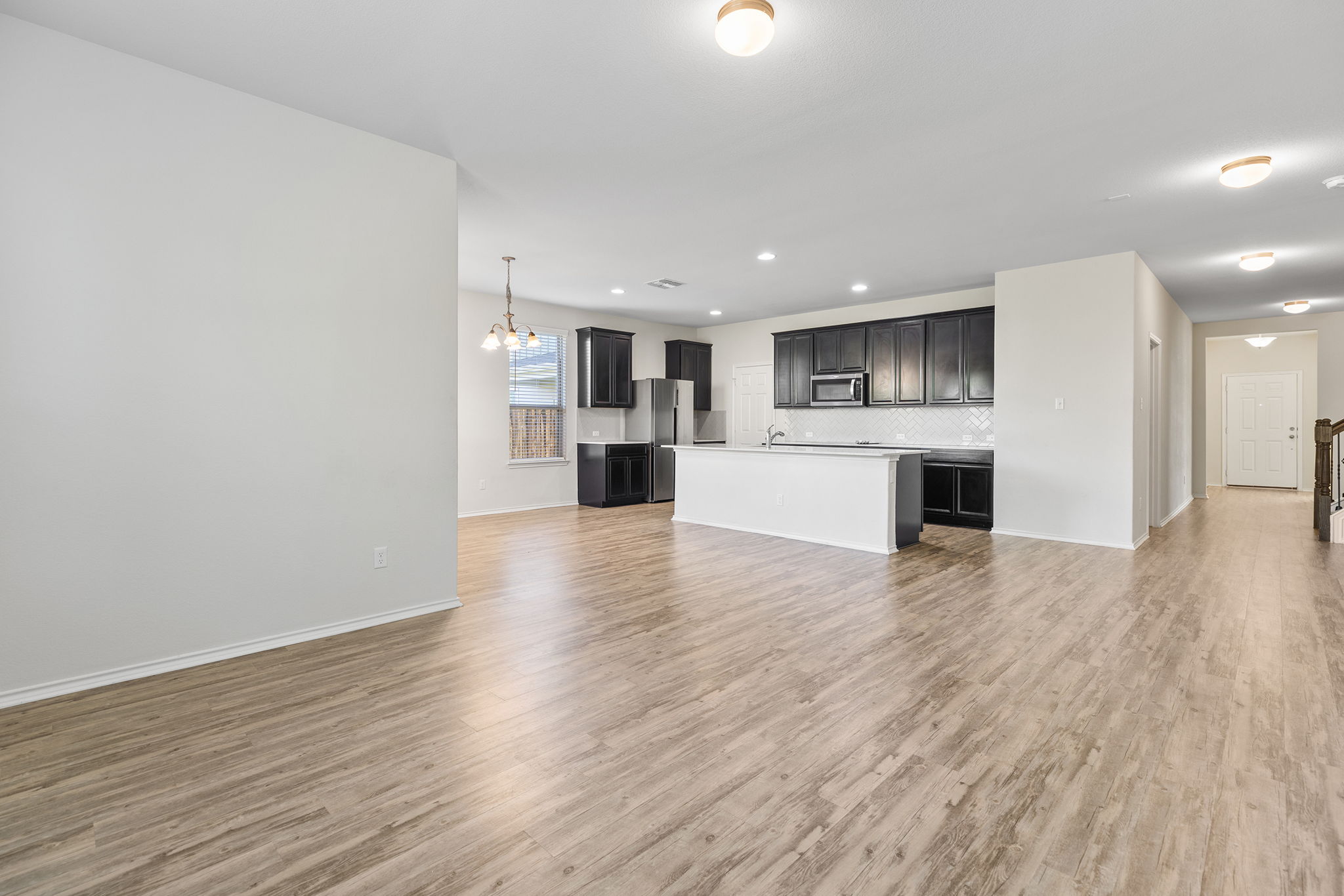332 Spotted Rail Ridge Leander, TX 78641 - Photo 11 of 38 Unfurnished living room featuring a chandelier, light wood-style floors, and recessed lighting