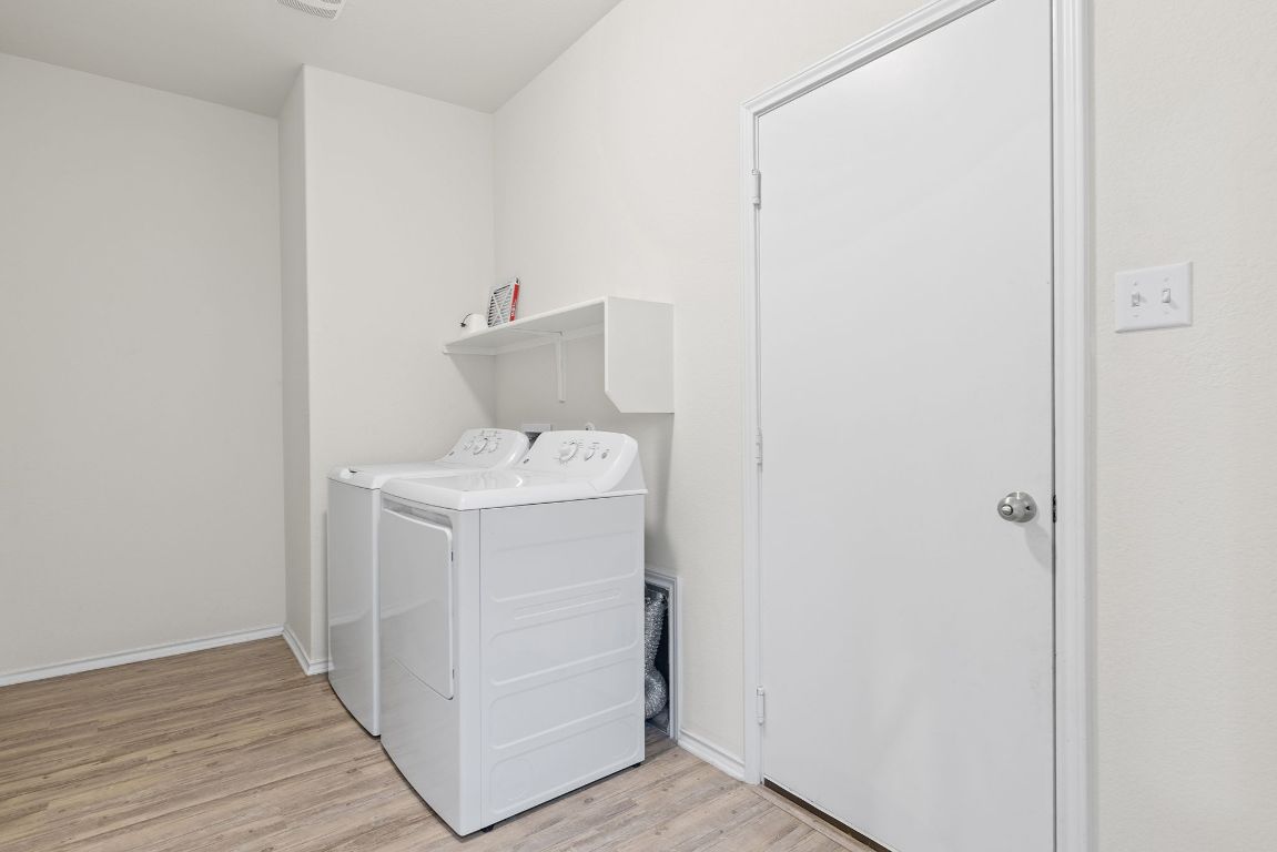 332 Spotted Rail Ridge Leander, TX 78641 - Photo 19 of 35 Laundry room featuring light wood-style flooring and washing machine and dryer