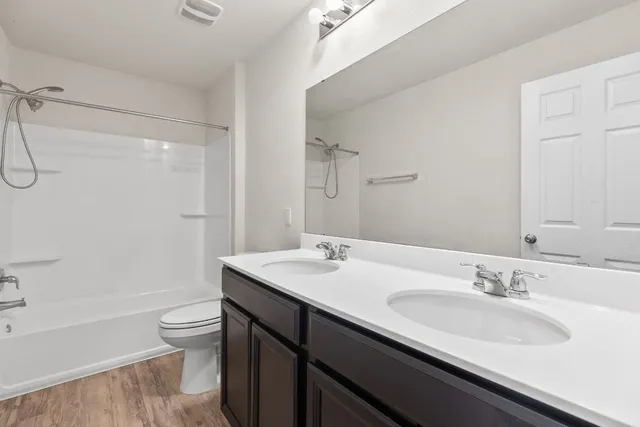 a bathroom with a granite countertop sink a toilet and shower