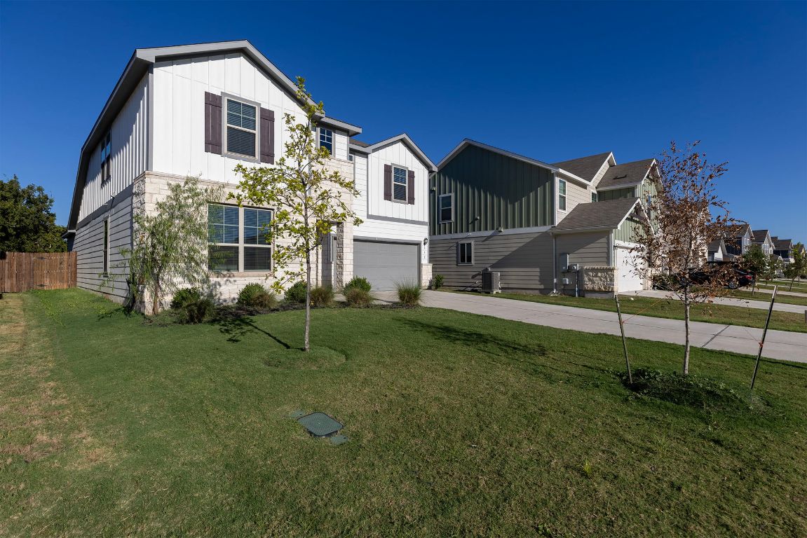 332 Spotted Rail Ridge Leander, TX 78641 - Photo 33 of 35 View of front of property with board and batten siding, driveway, and an attached garage