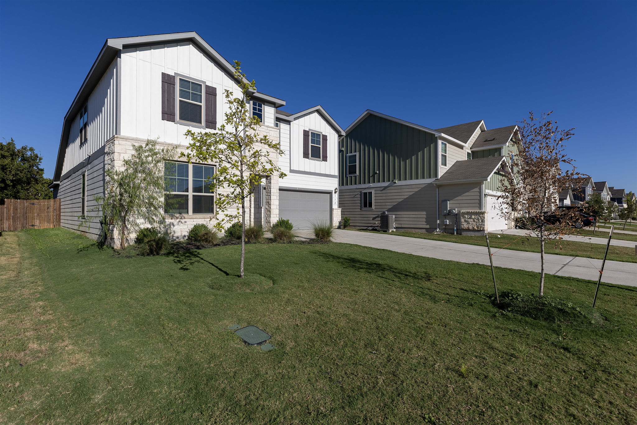 332 Spotted Rail Ridge Leander, TX 78641 - Photo 35 of 38 View of front of property with board and batten siding, driveway, and an attached garage