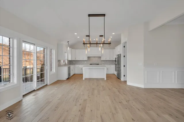 a view of kitchen with granite countertop cabinets and refrigerator