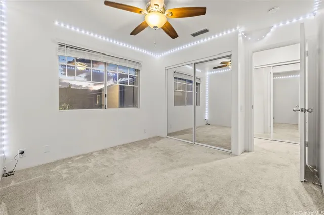 an empty room with a window and a fan