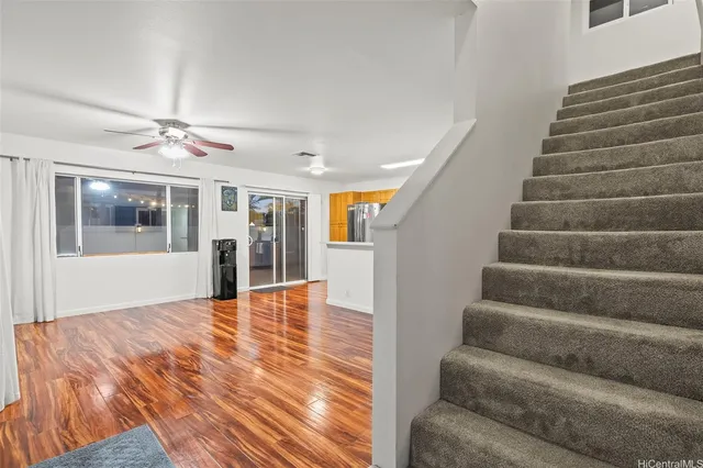 a view of an entryway with wooden floor and a kitchen view