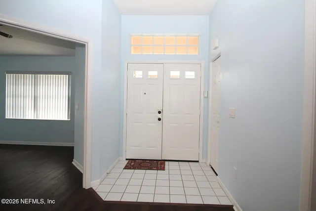 a view of a hallway with wooden floor and a bathroom