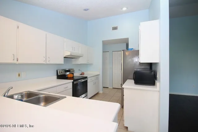 a kitchen with a sink a stove and refrigerator
