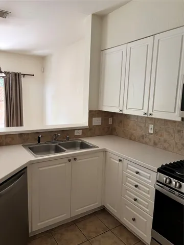 a kitchen with granite countertop white cabinets and white appliances