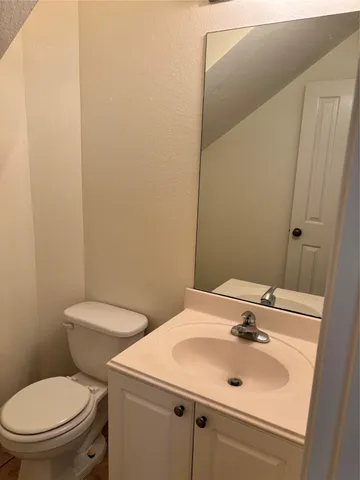 a bathroom with a sink a toilet and mirror