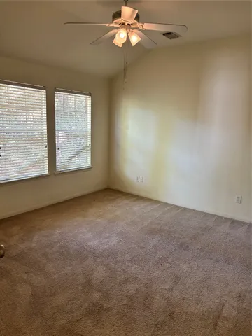 an empty room with a window and a fan