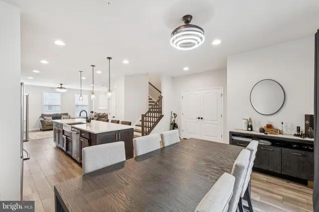 a living room with furniture kitchen view and a wooden floor