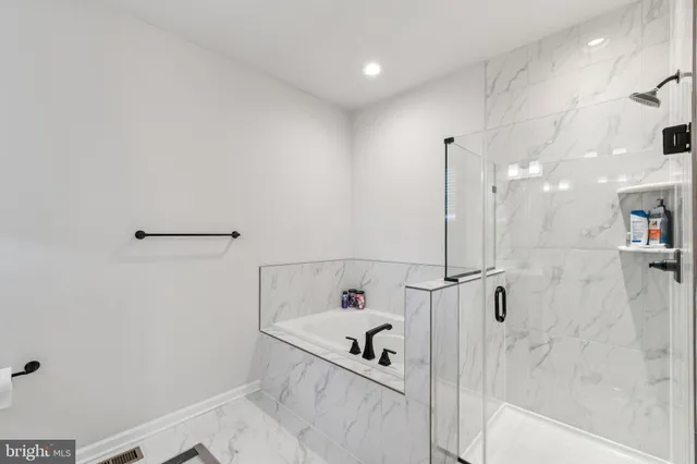 a bathroom with a white bath tub and shower