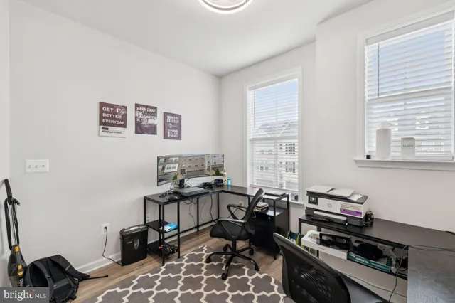 a view of a workspace with furniture and a window