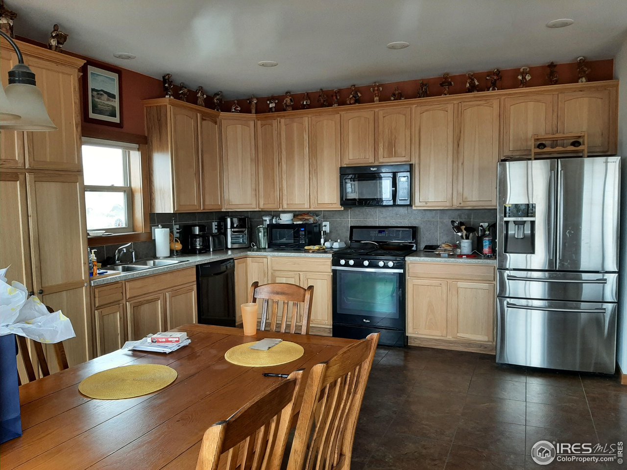 2865 Davis Ranch Road Bellvue, CO 80512 - Photo 9 of 38 a kitchen with granite countertop stainless steel appliances a sink a stove a refrigerator cabinets and a dining table