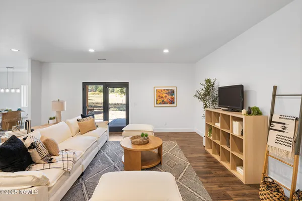 a kitchen with stainless steel appliances granite countertop a dining table chairs refrigerator and microwave