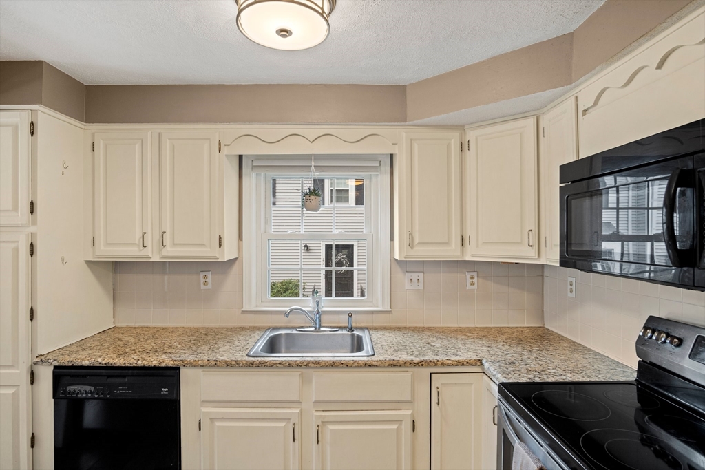 20 Casey Circle, Unit 20 Waltham, MA 02451 - Photo 5 of 38 a kitchen with granite countertop a sink stainless steel appliances and cabinets