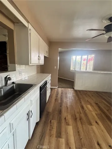 a kitchen with granite countertop a sink dishwasher stove and cabinets