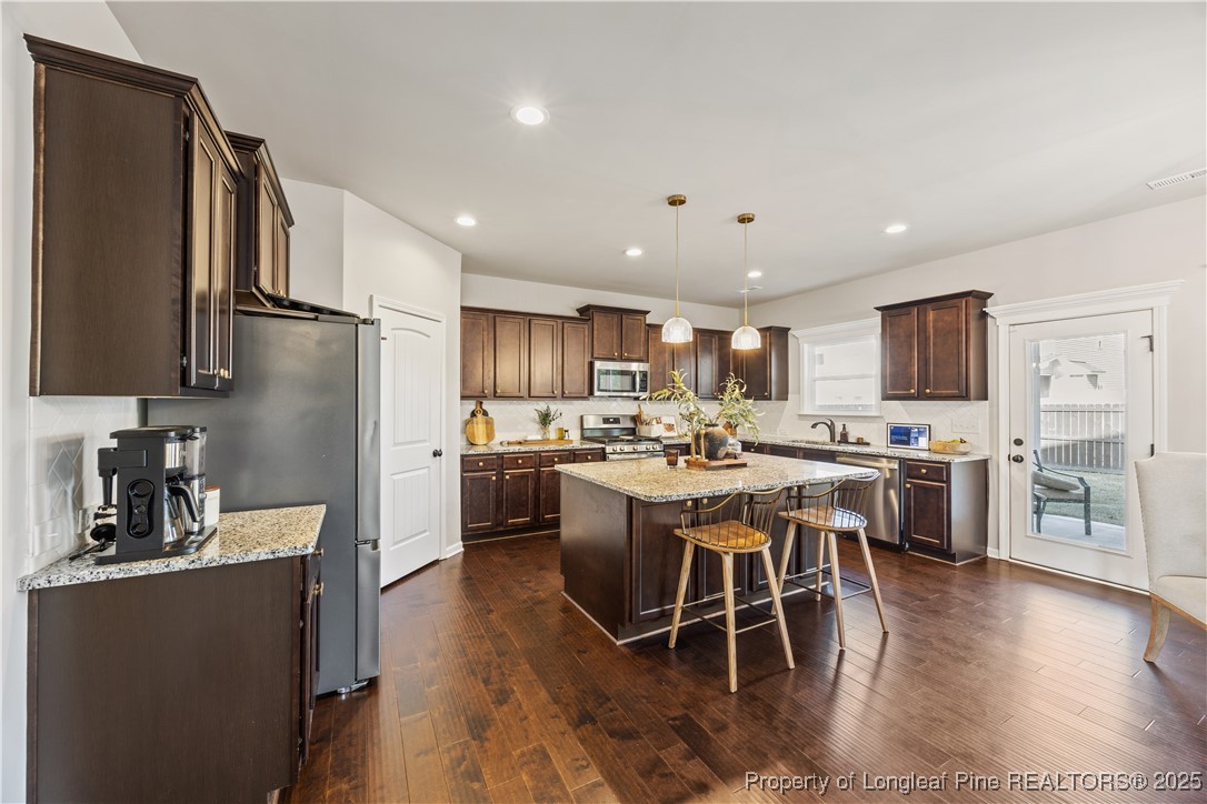 1709 Eagle Hill Road Fayetteville, NC 28312 - Photo 20 of 46 a kitchen with stainless steel appliances granite countertop a table chairs refrigerator and a sink