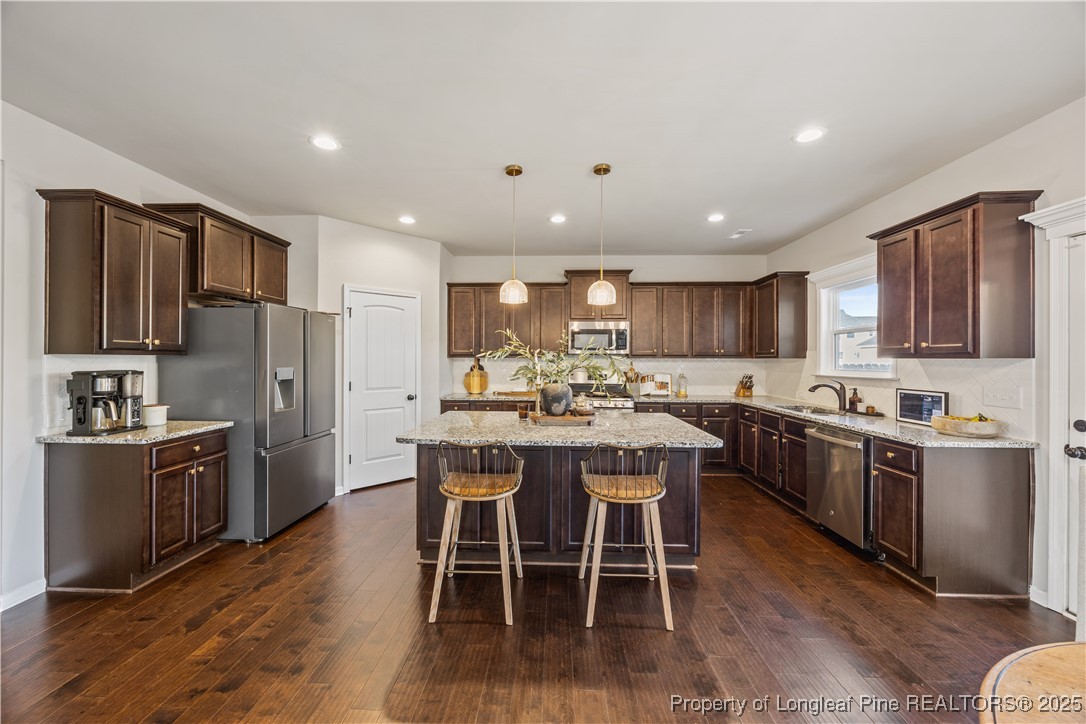 1709 Eagle Hill Road Fayetteville, NC 28312 - Photo 21 of 46 a kitchen with stainless steel appliances granite countertop a table chairs sink refrigerator and microwave