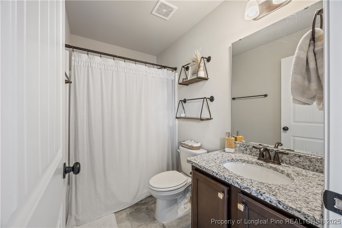 1709 Eagle Hill Road Fayetteville, NC 28312 - Photo 27 of 46 a bathroom with a granite countertop sink toilet and shower