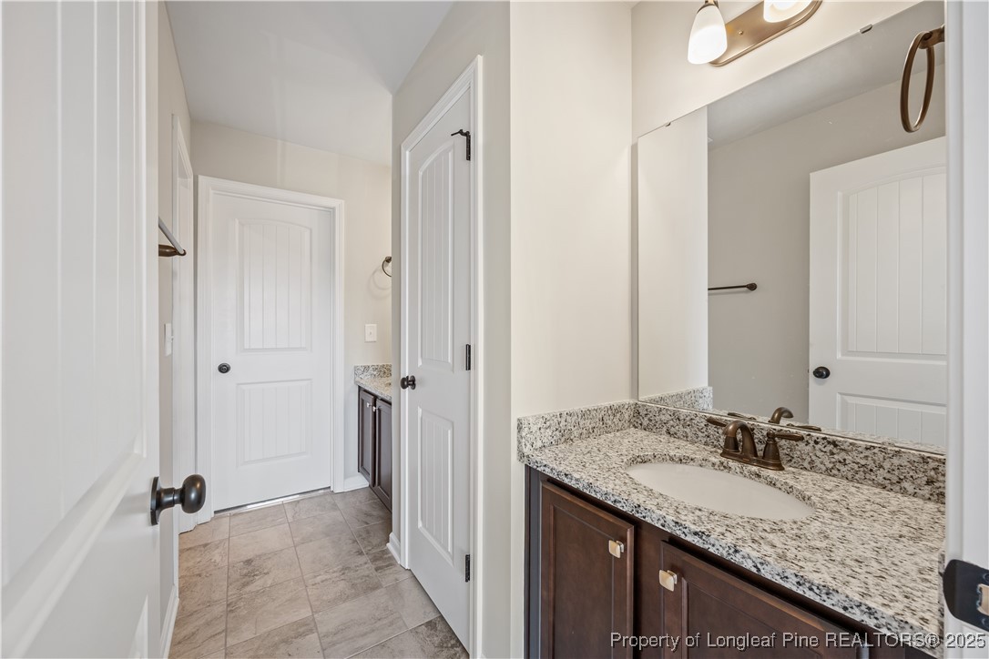 1709 Eagle Hill Road Fayetteville, NC 28312 - Photo 39 of 46 a bathroom with a granite countertop sink and a mirror