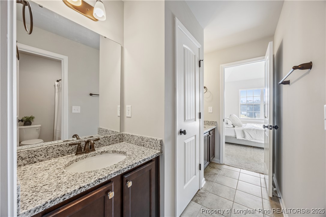 1709 Eagle Hill Road Fayetteville, NC 28312 - Photo 40 of 46 a bathroom with a granite countertop sink and a mirror