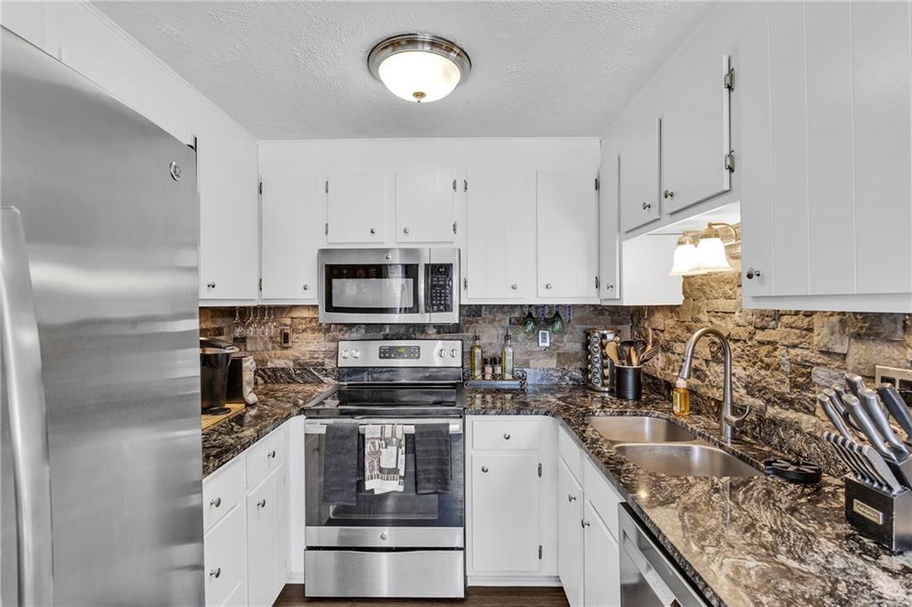 4 B Springwood Square Harwick, PA 15049 - Photo 10 of 32 a kitchen with granite countertop a sink stainless steel appliances and white cabinets