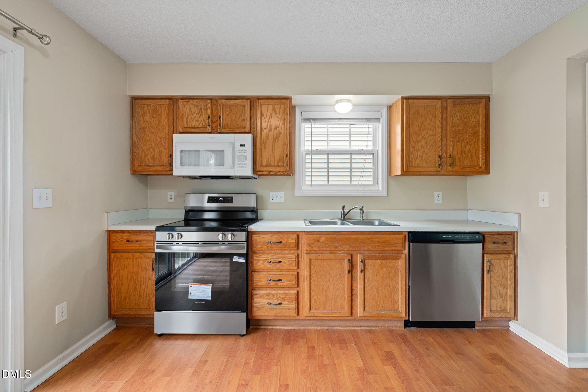 4701 Tommans Trail Raleigh, NC 27616 - Photo 23 of 36 a kitchen with stainless steel appliances granite countertop a stove a sink and a microwave