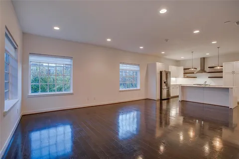 a view of kitchen with kitchen island granite countertop wooden floors and wide window