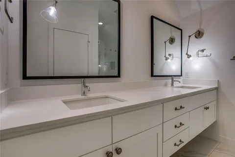 a bathroom with double sink and a mirror