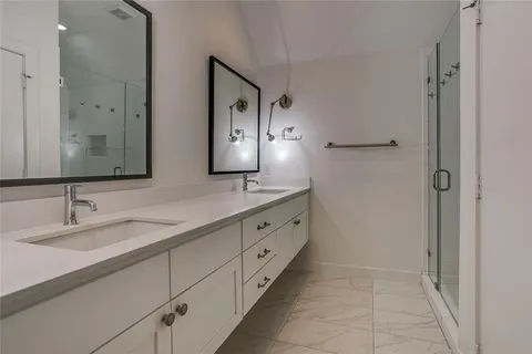 a spacious bathroom with a double vanity sink and mirror
