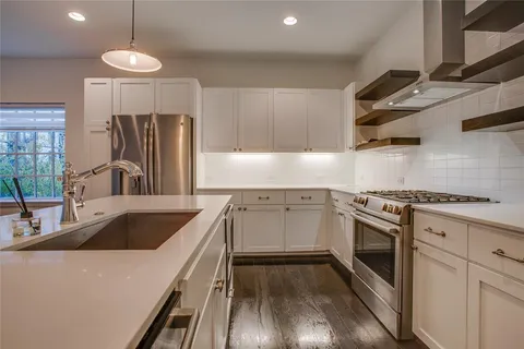 a kitchen with granite countertop a sink stainless steel appliances and cabinets