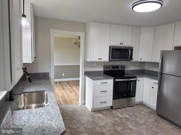 a kitchen with granite countertop a sink and a stove