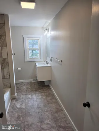 a bathroom with a sink toilet and window