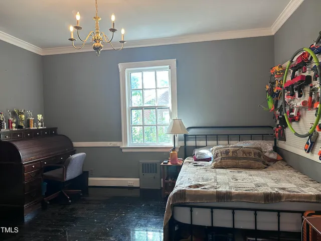 a bedroom with a bed and a chandelier